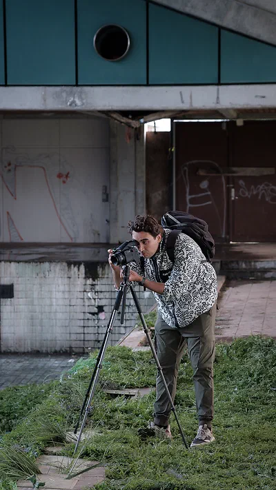 Kristoffer Trolle photographing with a camera on a tripod in an abandoned concrete building