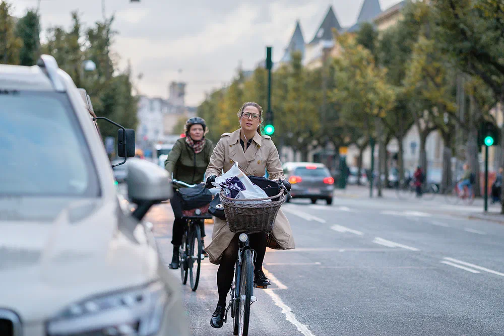 Woman cycling with shopping bags on Frederiksberg Allé