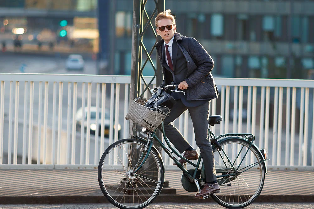 Man in a suit and sunglasses cycling on Knippelsbro