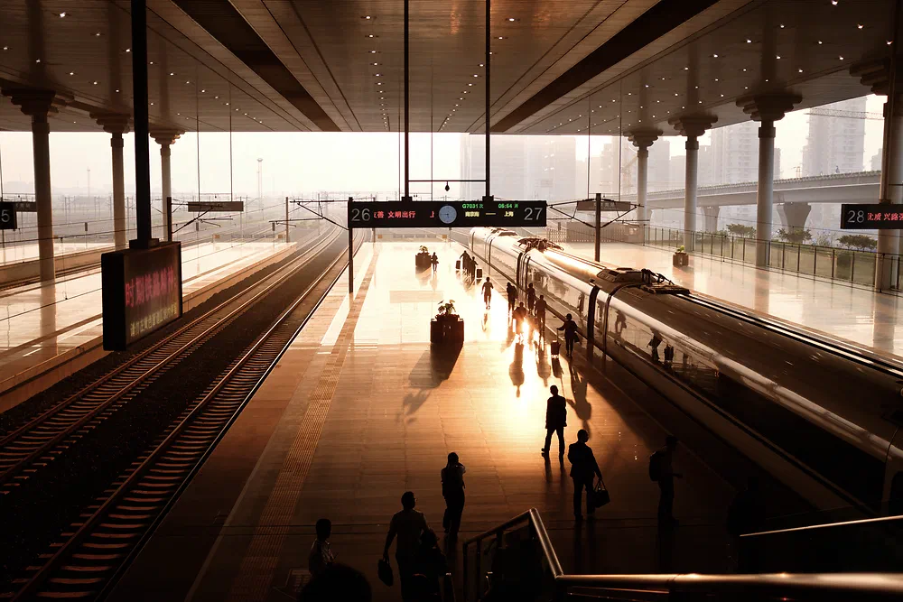 Silhouettes of travellers on a platform at Nanjing South Railway Station in early morning light