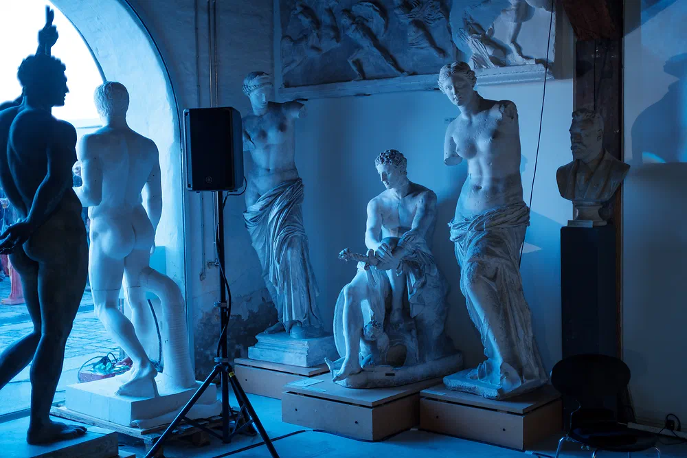 Group of plaster cast statues lit in blue light