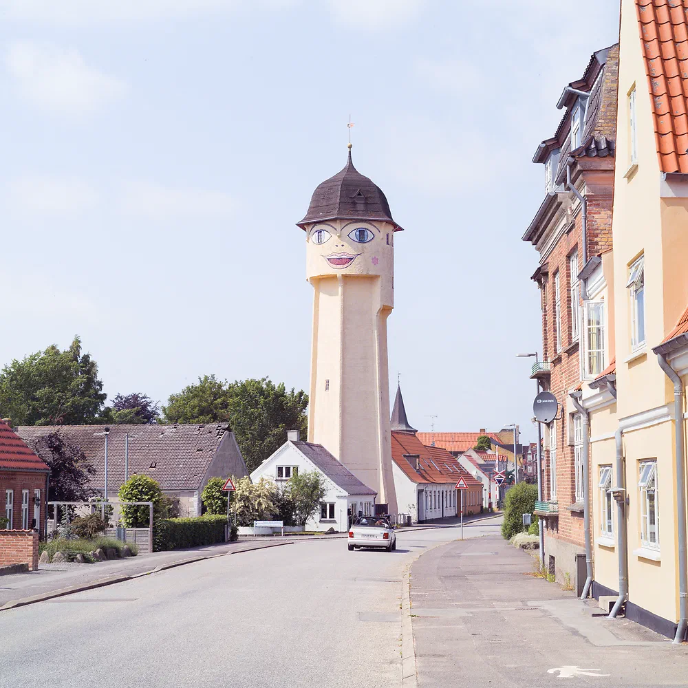 Sakskøbing water tower with its painted smiling face at the end of a small town street