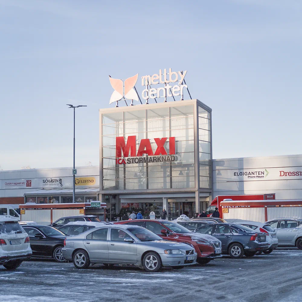 Maxi supermarket at Mellby Center with cars in the snowy parking lot
