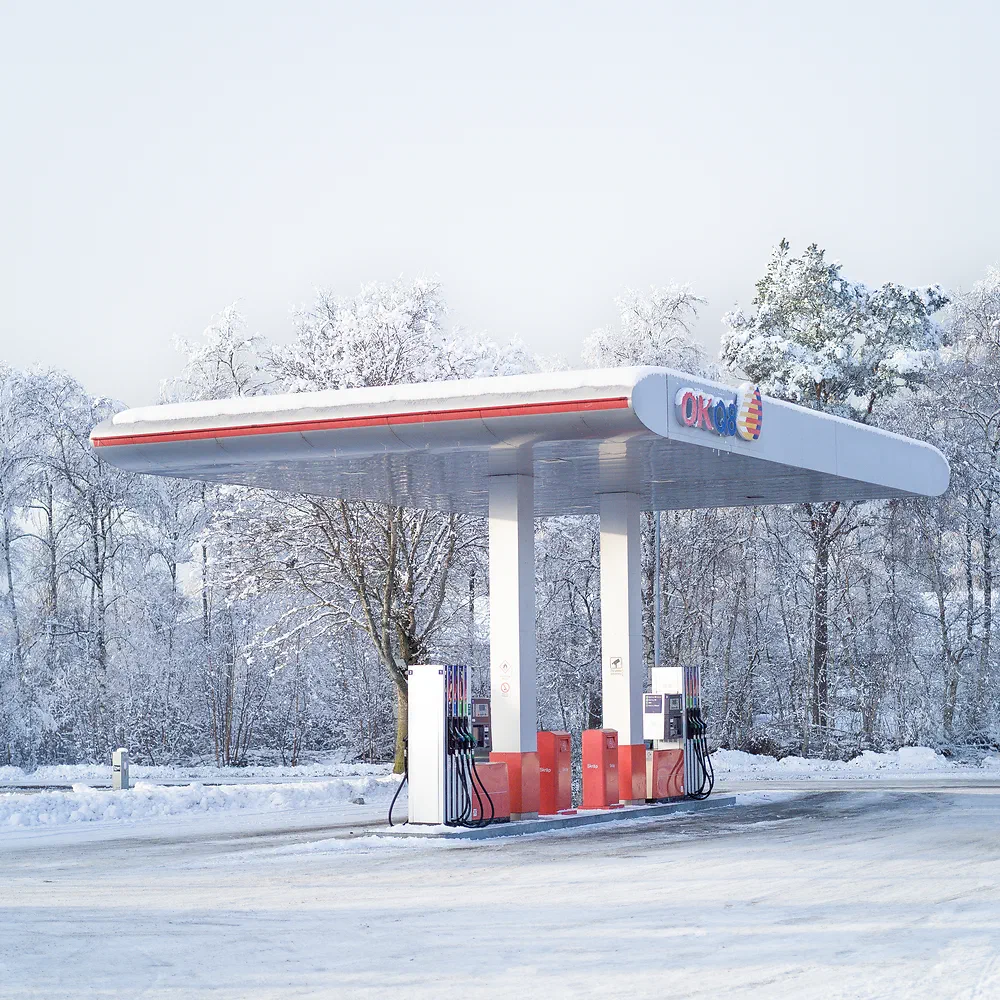 Empty gas station surrounded by snow covered trees