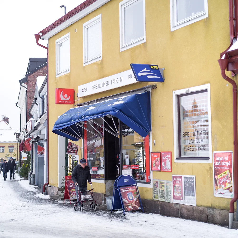 Yellow corner kiosk on a snowy street in Laholm