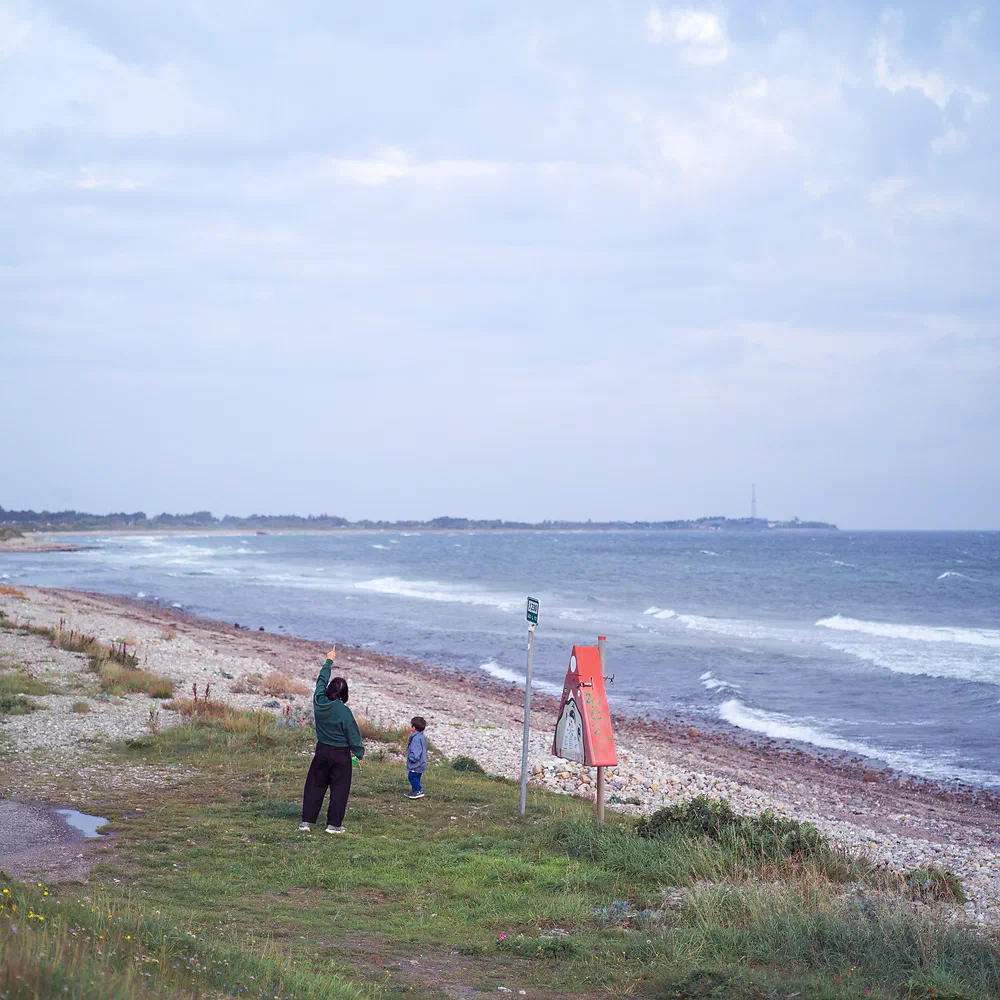 Family on a windy beach at Sjællands Odde with waves rolling in along the coastline