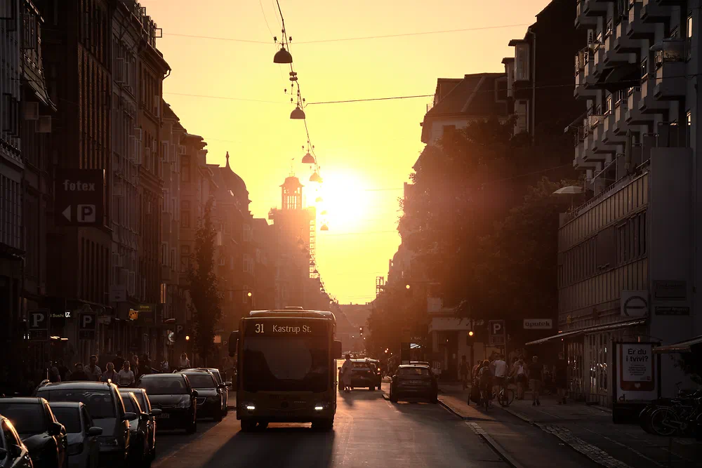 Sun setting at the end of Gammel Kongevej with a bus and parked cars